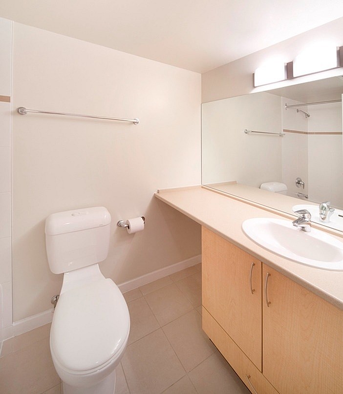 A white toilet sits next to a sink in a bathroom.