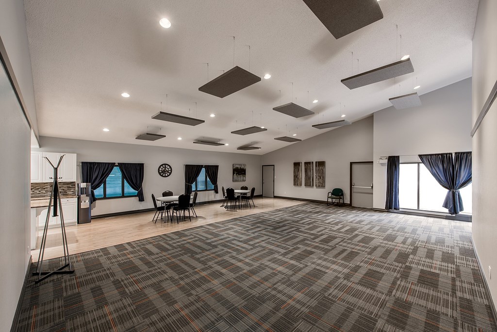 A large room with grey carpeting and a white ceiling.