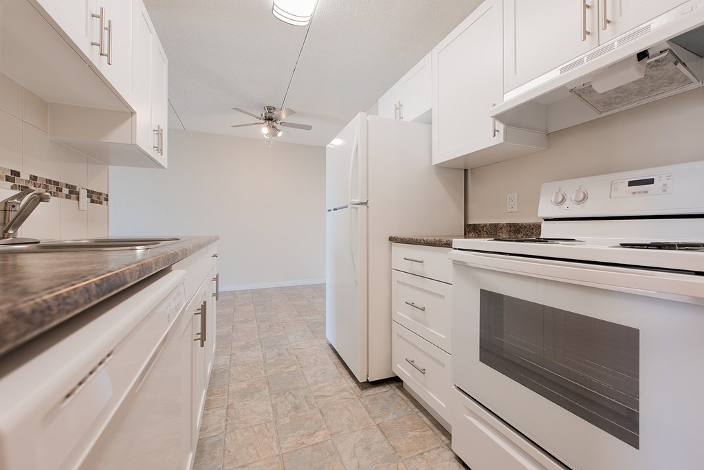 A kitchen with white appliances and cabinets.
