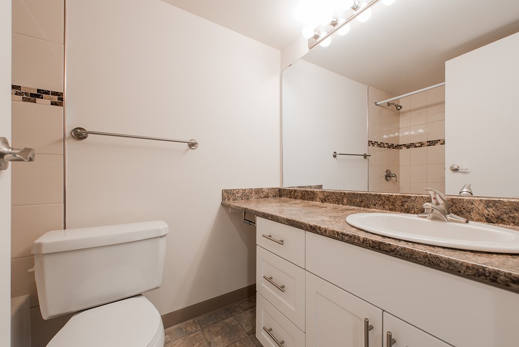 A white toilet sits next to a sink in a bathroom.
