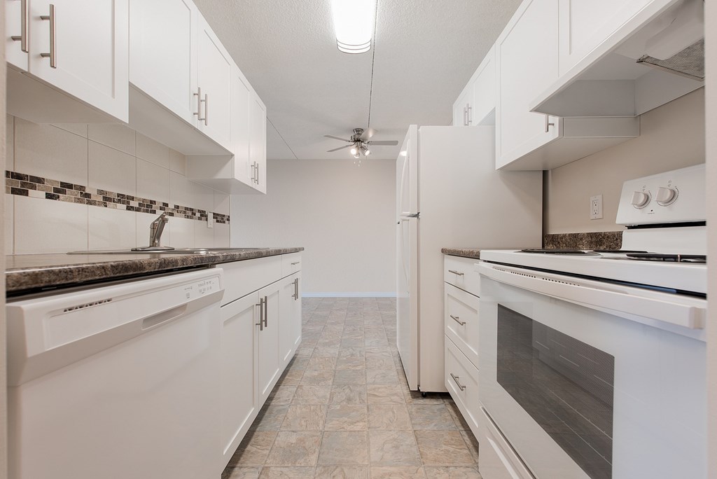 A kitchen with white appliances and cabinets.