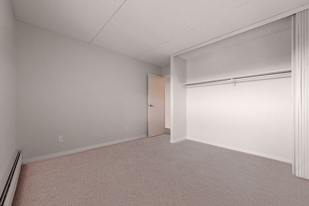 A room with a carpeted floor and a door.