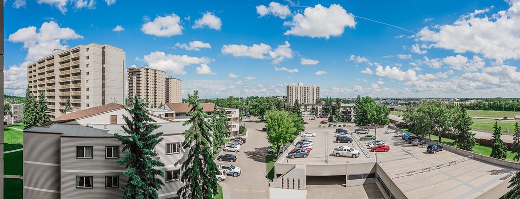 A parking lot with cars and a building in the background.