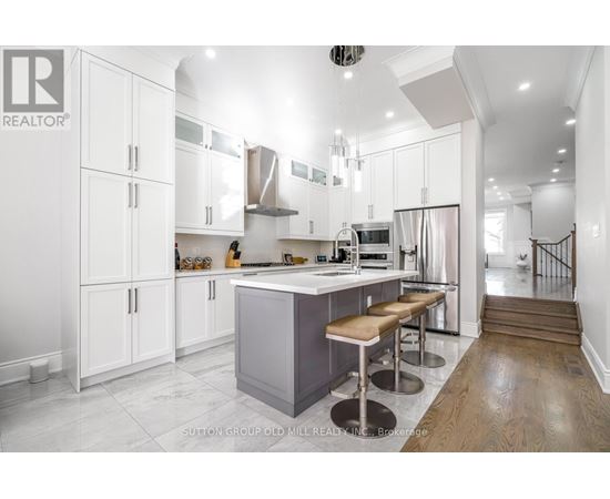 A modern kitchen with white cabinets and a central island.