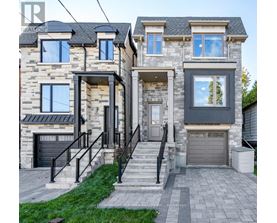 A house with a stone facade and a black garage door.