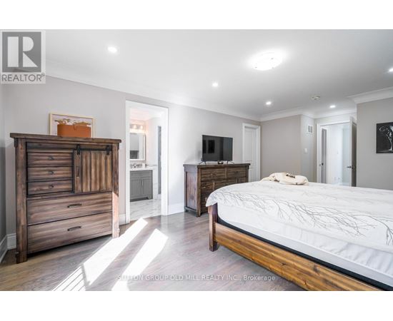 A bedroom with a large bed and a wooden dresser.