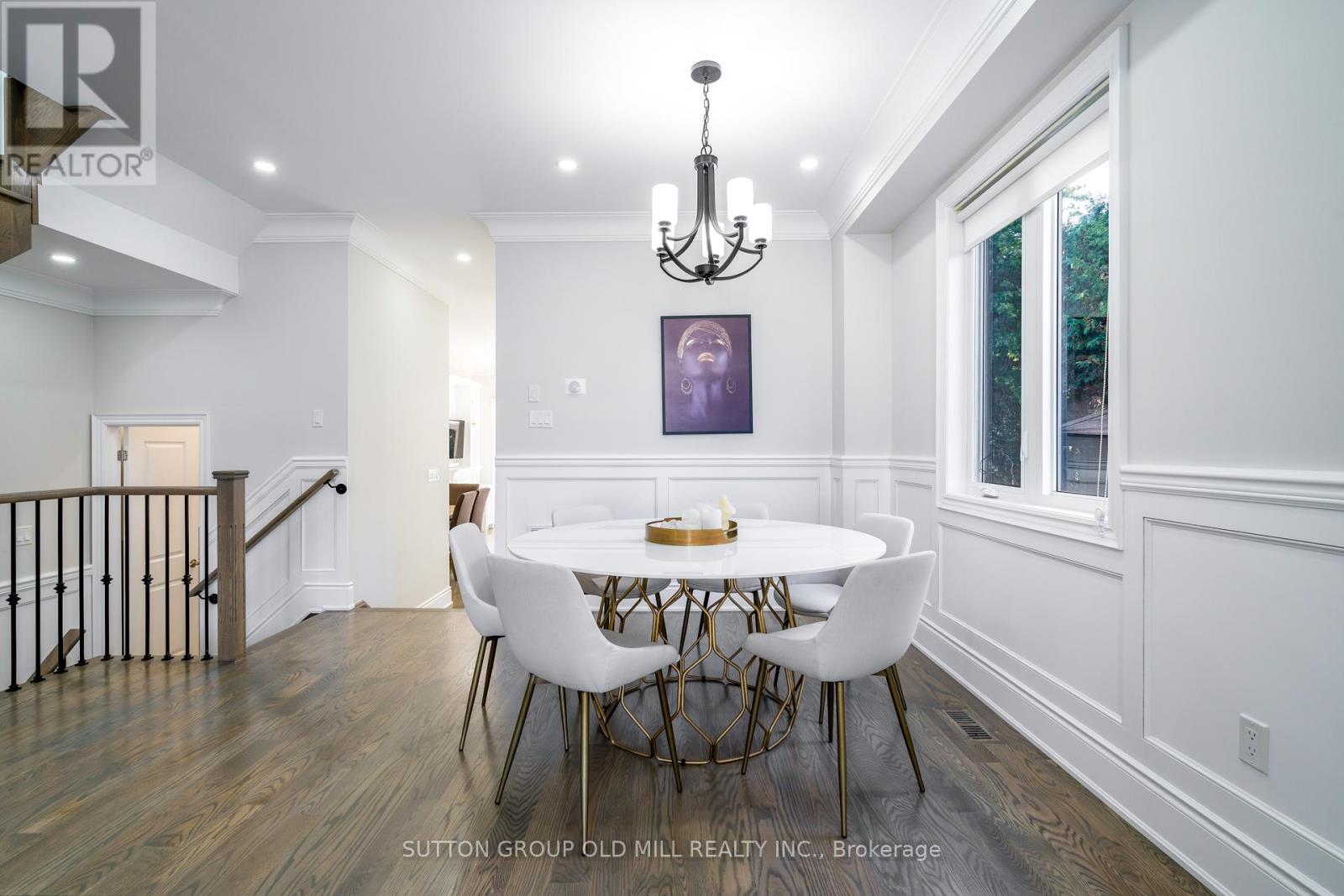 A dining room with a white table and chairs.