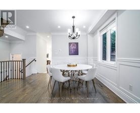 A dining room with a white table and chairs.