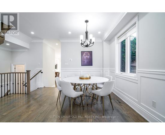 A dining room with a white table and chairs.