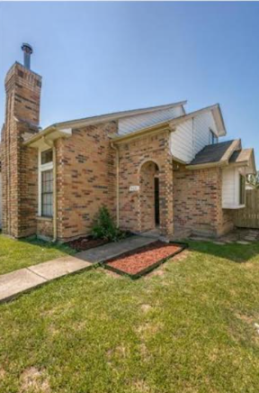 A house with a brick facade and a chimney.