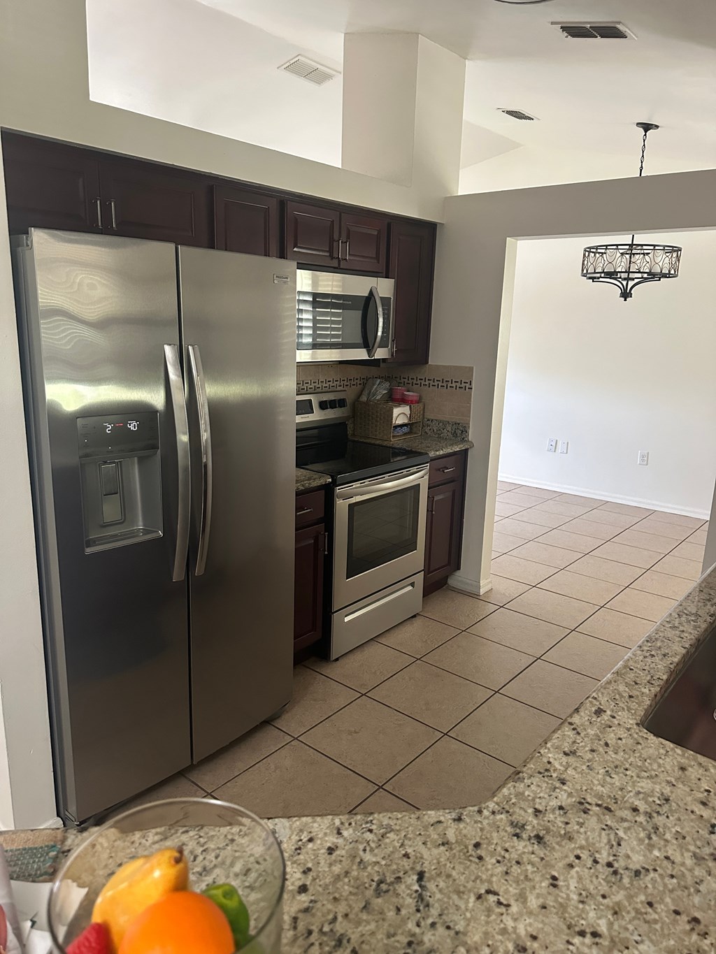 A kitchen with a granite counter top and stainless steel appliances.