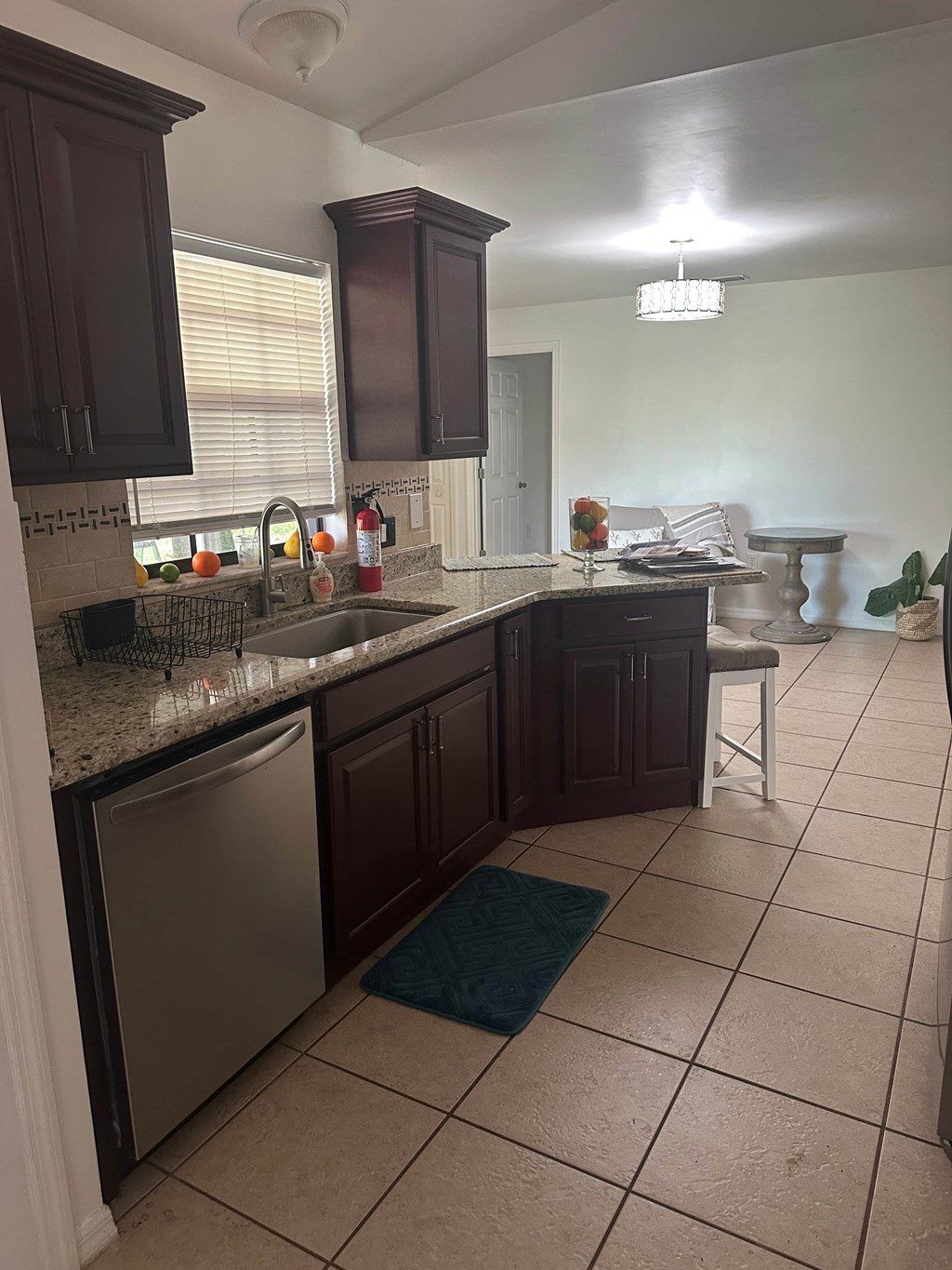 A kitchen with brown cabinets and a tiled floor.