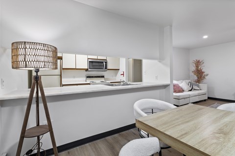 A modern dining room with a wooden table and white chairs.