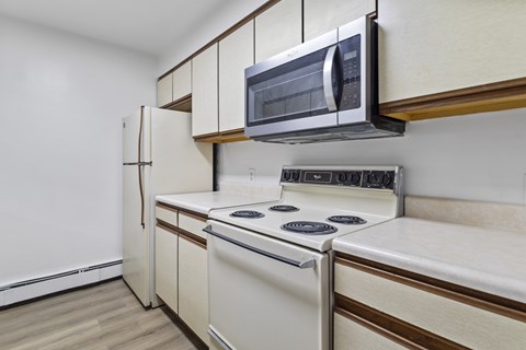 A kitchen with a white stove and a microwave above it.