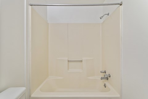 A white bathroom with a toilet and a bathtub.