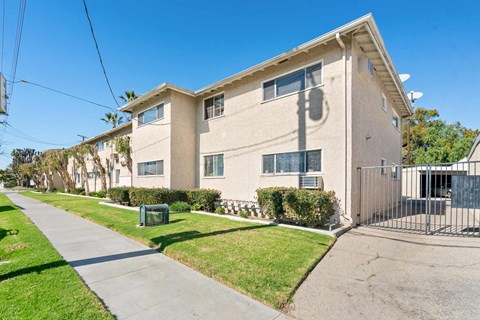 A residential building with a green lawn in front.
