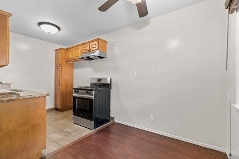 A kitchen with a black stove top oven and a wooden cabinet.