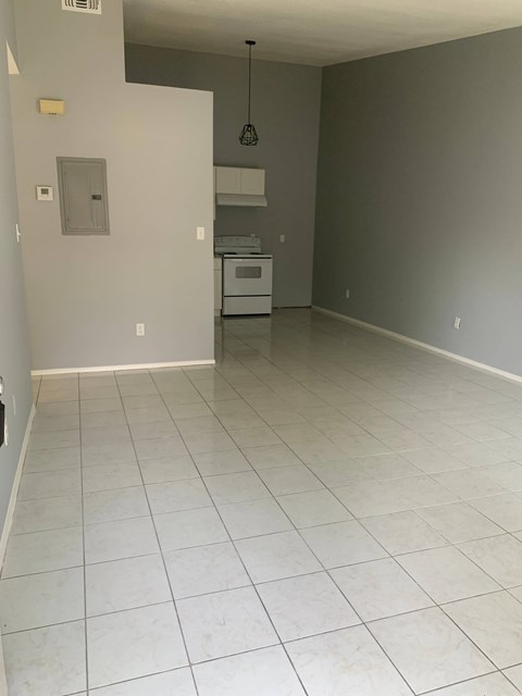 A kitchen with white tile flooring and a white oven.
