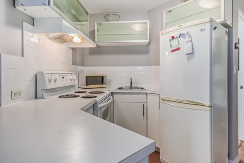 A white refrigerator with a few magnets on it is in a kitchen.