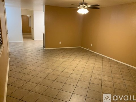 A spacious room with a ceiling fan and tiled flooring.