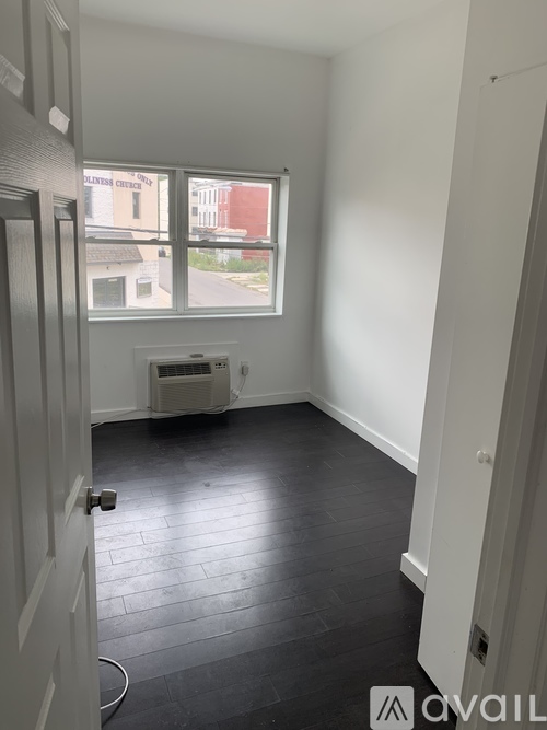 A room with a window and a wall-mounted air conditioner.