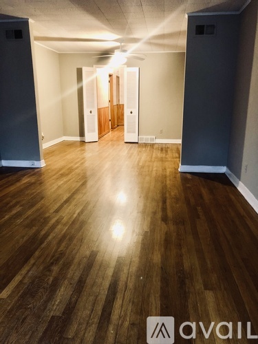 A hallway with wooden floors and white walls.