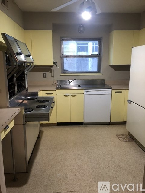 A kitchen with yellow cabinets and a window.