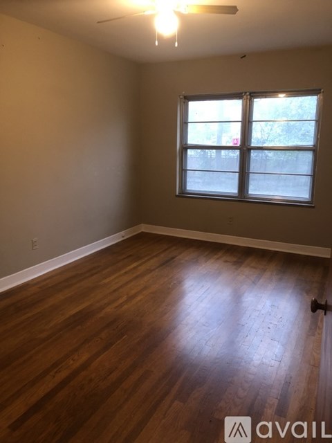 A room with wooden flooring and a window.
