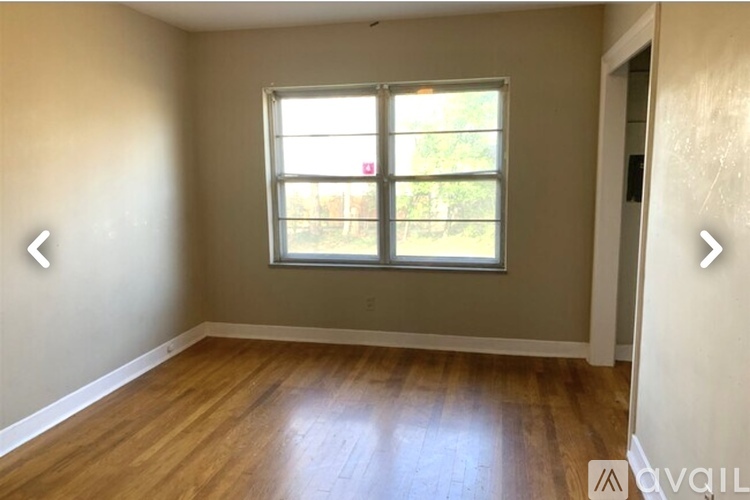 A room with a window and wooden flooring.