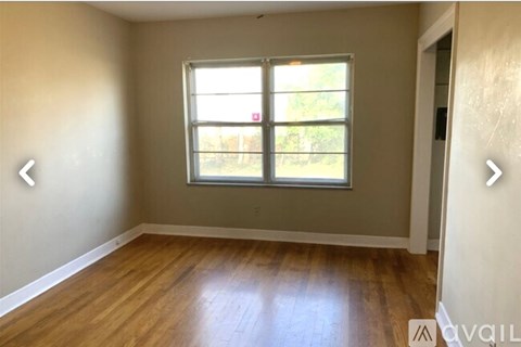 A room with a window and wooden flooring.