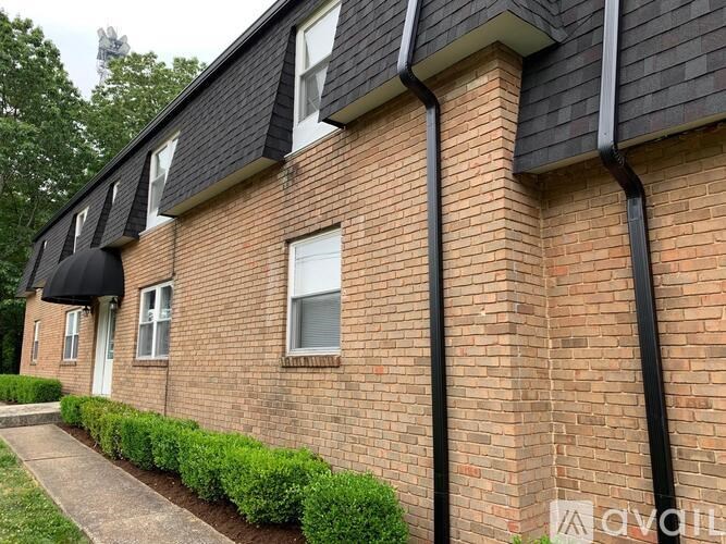 A brick building with a black awning and a white door.