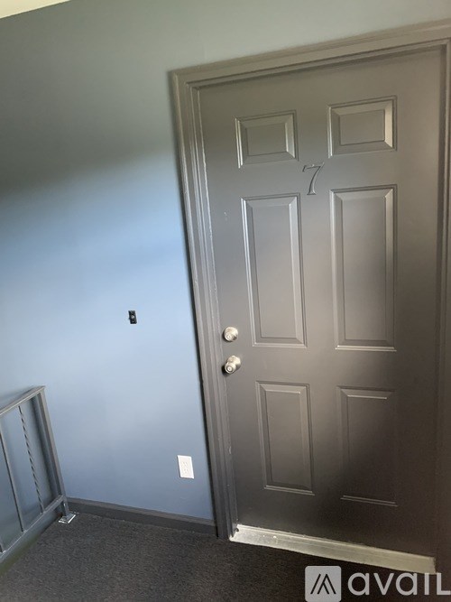 A grey door with a handle and a keyhole.