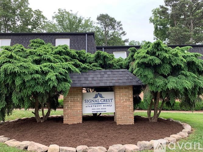 A sign for Signal Crest Apartment Homes is in front of a building.