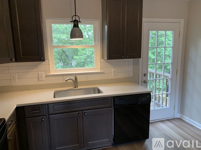 A kitchen with dark brown cabinets and a white sink.