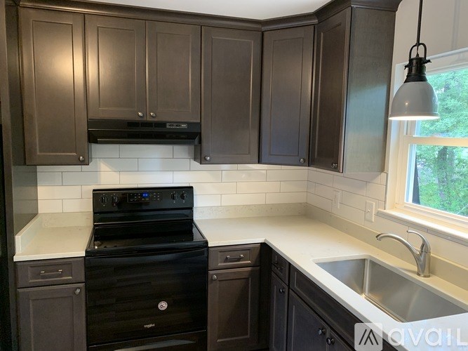 A kitchen with dark brown cabinets and a black stove top oven.