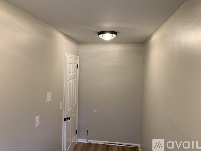 A room with a white door and a light on the ceiling.