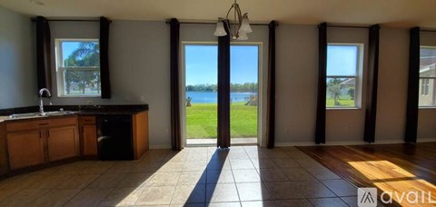 A kitchen with a sink and a window overlooking a body of water.