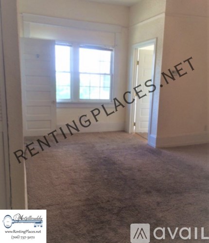 A room with a carpeted floor and a window with blinds.