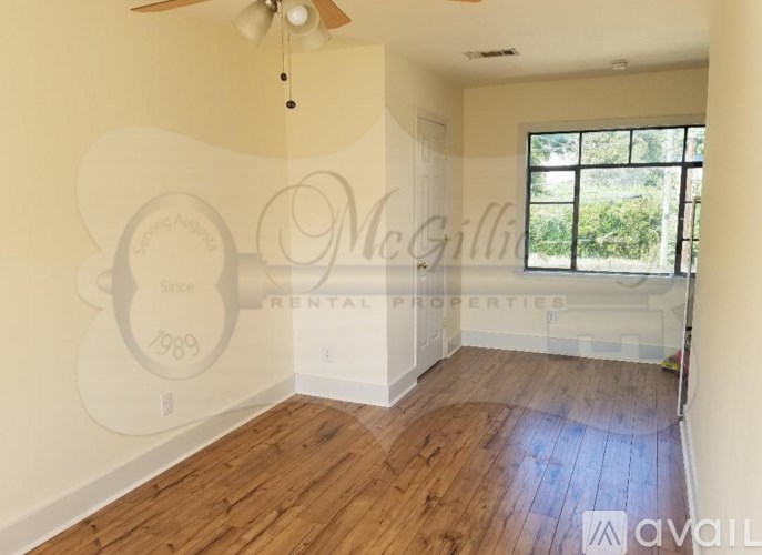 A room with wooden floors and a ceiling fan.