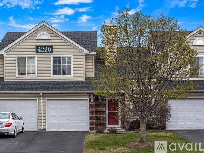 A house with the number 4220 on the front wall and a car parked in the driveway.