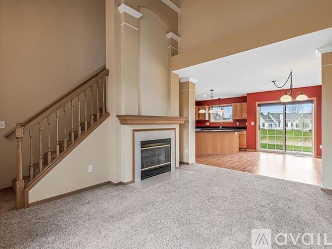 A living room with a fireplace and a staircase.