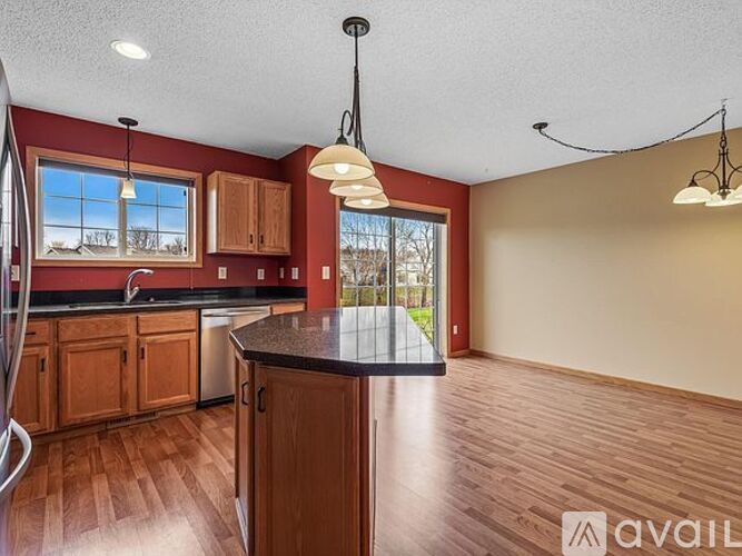 A kitchen with wooden cabinets and a black countertop.