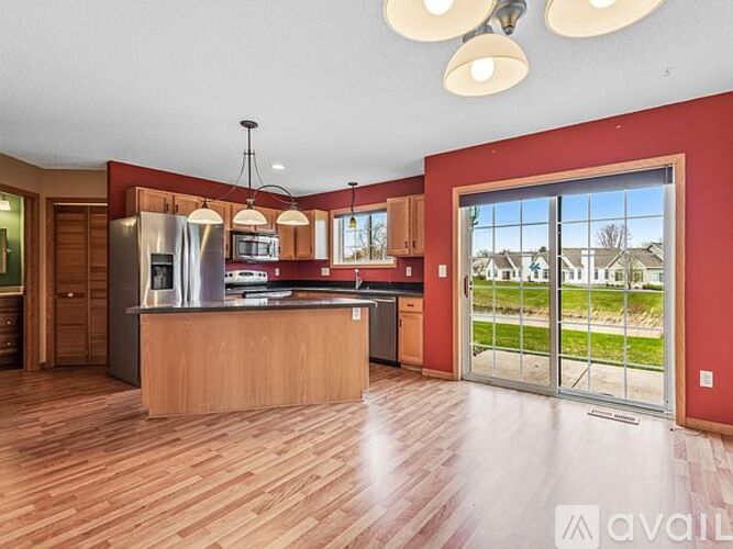 A kitchen with wooden floors and a large island in the middle.