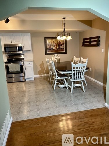 A kitchen with a dining table and chairs.