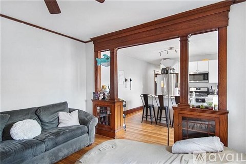 A living room with a grey couch and a wooden floor.