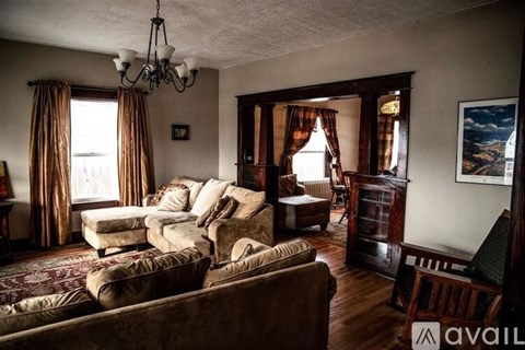 A living room with brown furniture and a chandelier.