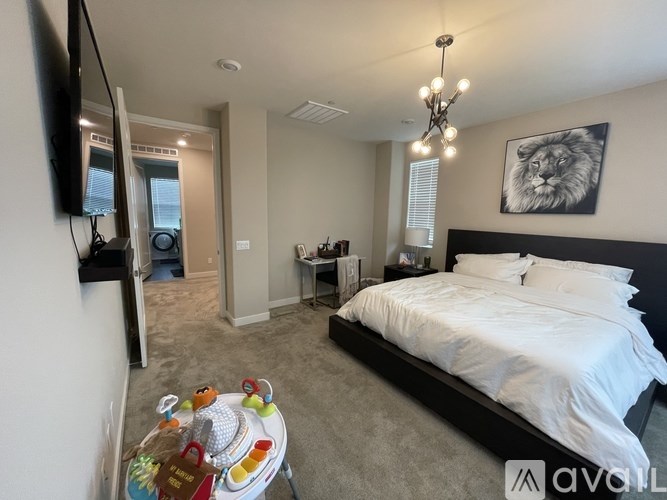 A bedroom with a large bed and a television on the wall.