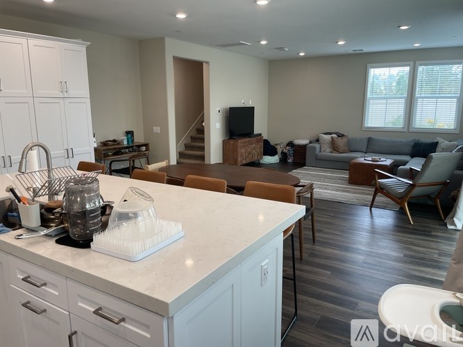 A kitchen with white cabinets and a marble countertop.