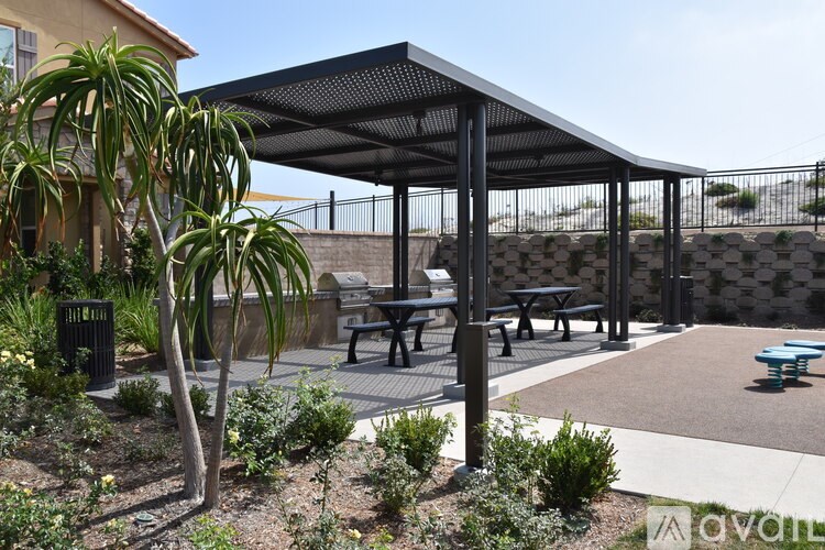 A patio with a black canopy and benches.