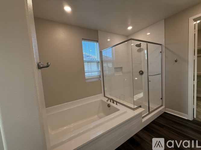 A bathroom with a white tub and a glass shower door.